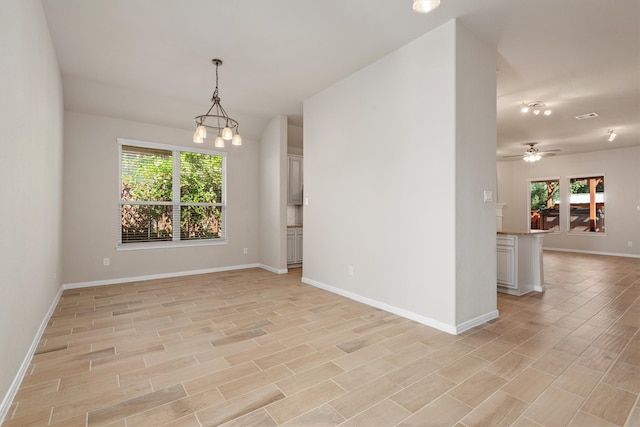 spare room with light hardwood / wood-style floors and ceiling fan with notable chandelier