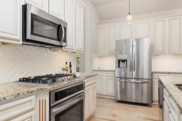 kitchen with light stone countertops, decorative light fixtures, stainless steel appliances, and decorative backsplash