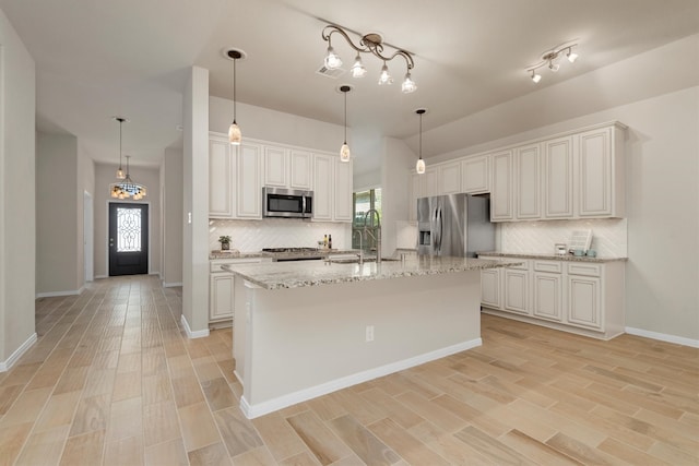 kitchen featuring white cabinets, stainless steel appliances, and a kitchen island with sink