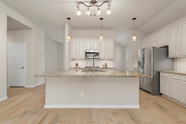 kitchen with backsplash, stainless steel appliances, and a kitchen island with sink