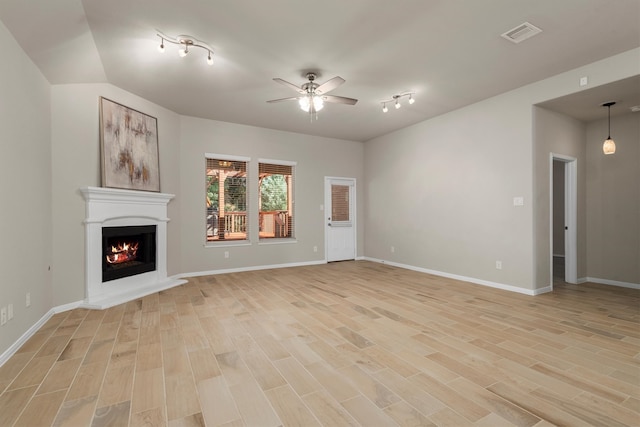 unfurnished living room featuring ceiling fan, light hardwood / wood-style floors, and rail lighting