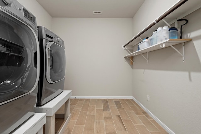 laundry area with light wood-type flooring and washing machine and dryer