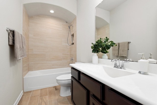 full bathroom with vanity, toilet, and tiled shower / bath combo