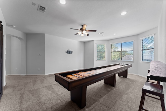 recreation room with a textured ceiling, carpet floors, and ceiling fan