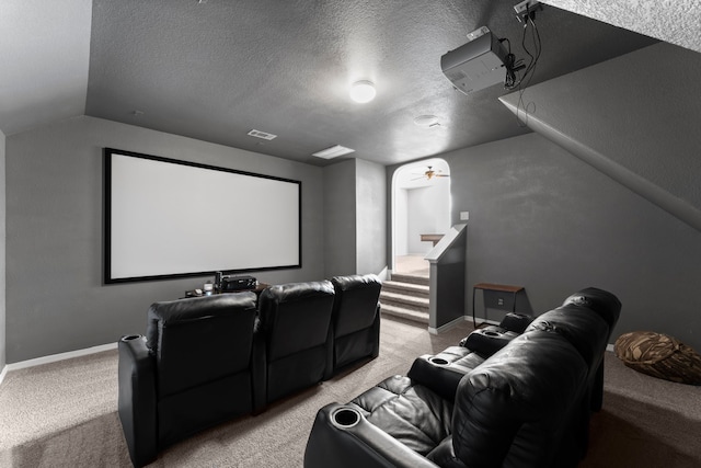 cinema with a textured ceiling, light colored carpet, and vaulted ceiling