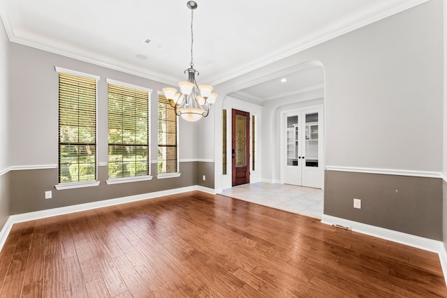 unfurnished dining area featuring light wood-type flooring, ornamental molding, and a wealth of natural light