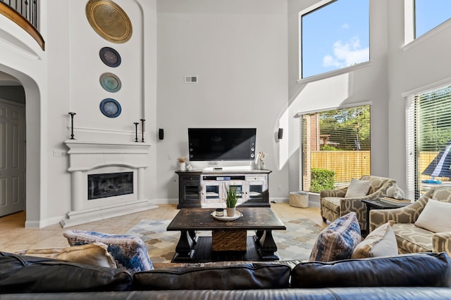 tiled living room featuring a high ceiling and a wealth of natural light