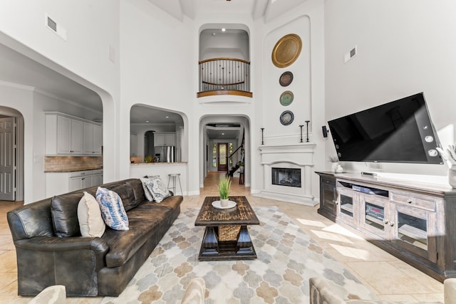 living room with crown molding and a high ceiling