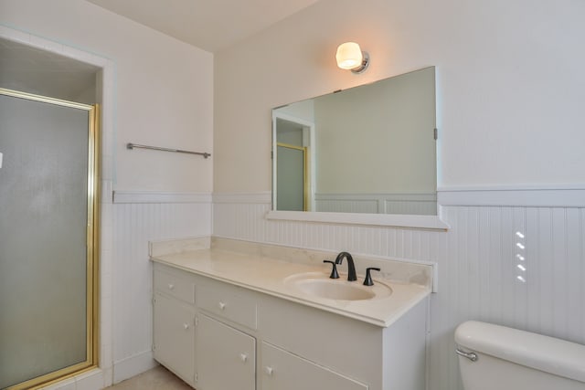 bathroom featuring vanity, toilet, and a shower with shower door