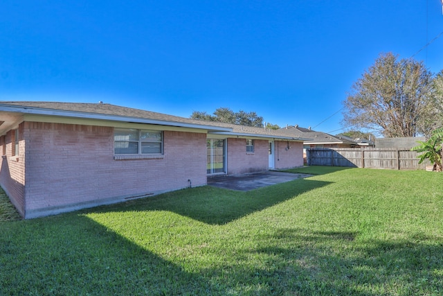 back of house with a patio area and a yard