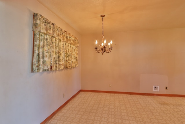 spare room with an inviting chandelier