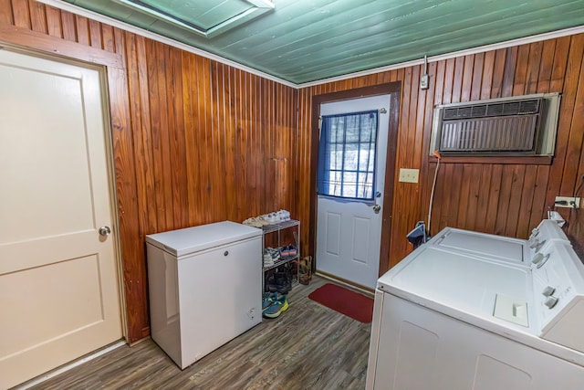 laundry room featuring an AC wall unit, wooden walls, washer and clothes dryer, and dark hardwood / wood-style flooring