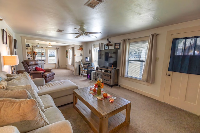 carpeted living room with ceiling fan and plenty of natural light