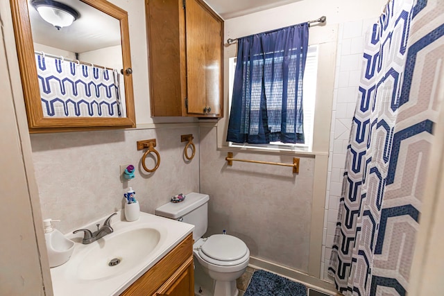 bathroom with a shower with shower curtain, vanity, and toilet