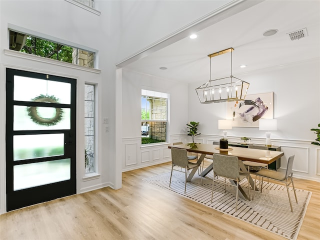 foyer featuring light hardwood / wood-style flooring, a notable chandelier, and ornamental molding