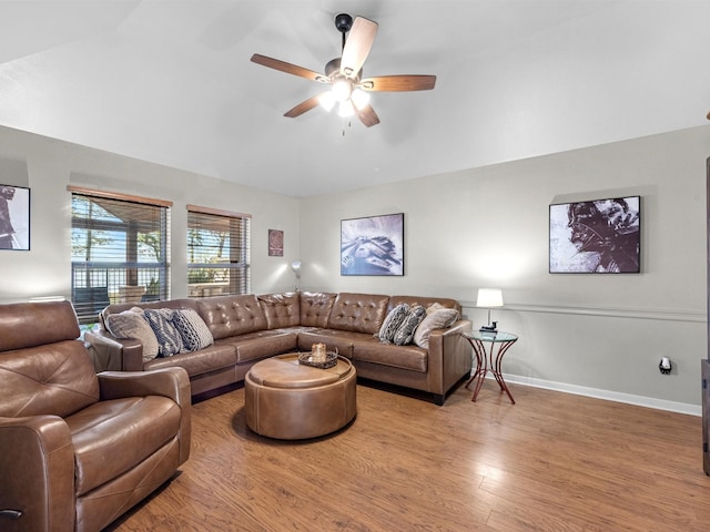 living room with ceiling fan, vaulted ceiling, and hardwood / wood-style flooring