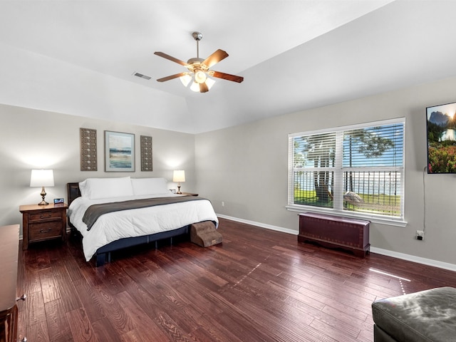 bedroom with ceiling fan, dark wood-type flooring, and lofted ceiling