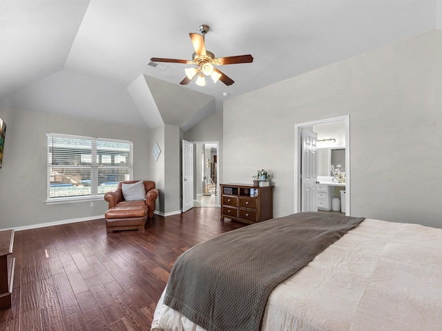 bedroom featuring ensuite bathroom, ceiling fan, dark wood-type flooring, and vaulted ceiling