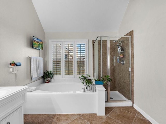 bathroom with tile patterned flooring, independent shower and bath, and lofted ceiling