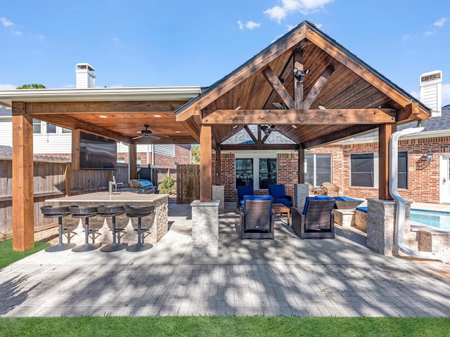 view of patio / terrace with a gazebo, outdoor lounge area, ceiling fan, and exterior bar