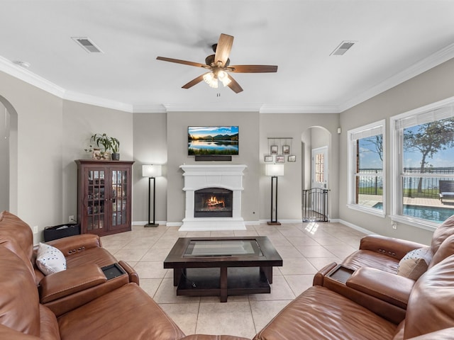 living room featuring ceiling fan, light tile patterned floors, and crown molding