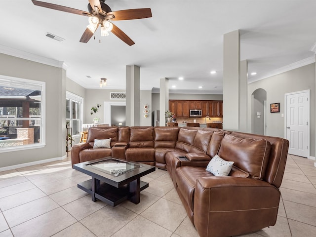 tiled living room featuring ceiling fan and crown molding