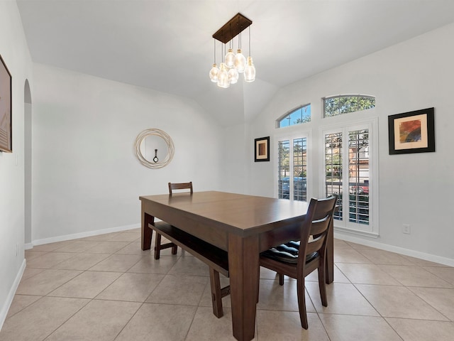 tiled dining area featuring vaulted ceiling and an inviting chandelier