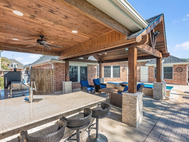 view of patio featuring exterior bar, outdoor lounge area, and ceiling fan