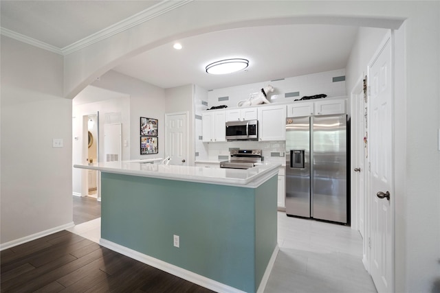 kitchen featuring a center island, tasteful backsplash, light hardwood / wood-style flooring, white cabinets, and appliances with stainless steel finishes