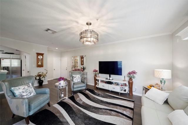 living room featuring dark hardwood / wood-style floors, crown molding, and a chandelier