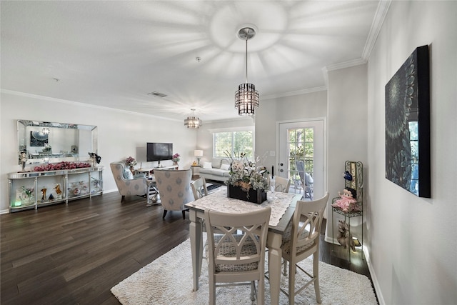 dining room with a notable chandelier, crown molding, and dark wood-type flooring