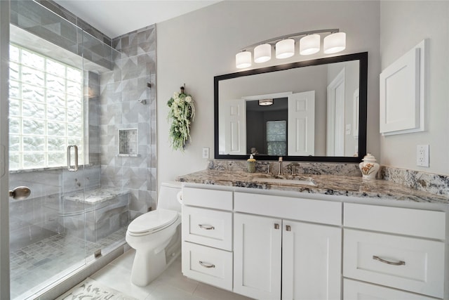 bathroom featuring a wealth of natural light, tile patterned flooring, vanity, and a shower with shower door