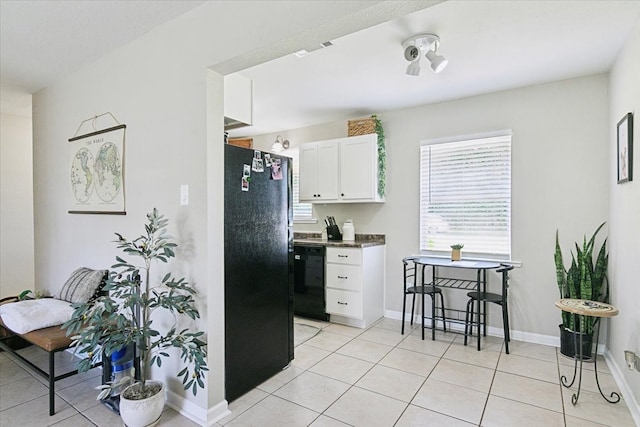 kitchen featuring white cabinets, black appliances, and light tile patterned floors