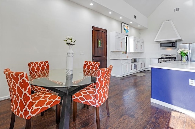 dining room with dark hardwood / wood-style flooring, sink, and high vaulted ceiling