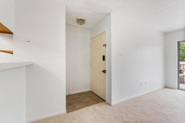 interior space featuring light carpet and a textured ceiling