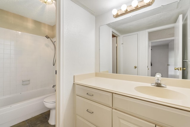 full bathroom featuring tile patterned floors, a textured ceiling, vanity, toilet, and tiled shower / bath