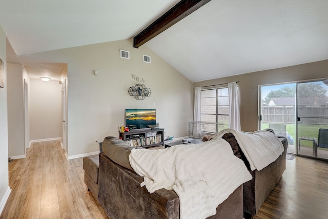 living room featuring lofted ceiling with beams and light hardwood / wood-style flooring