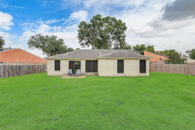 back of property with a yard and a patio area