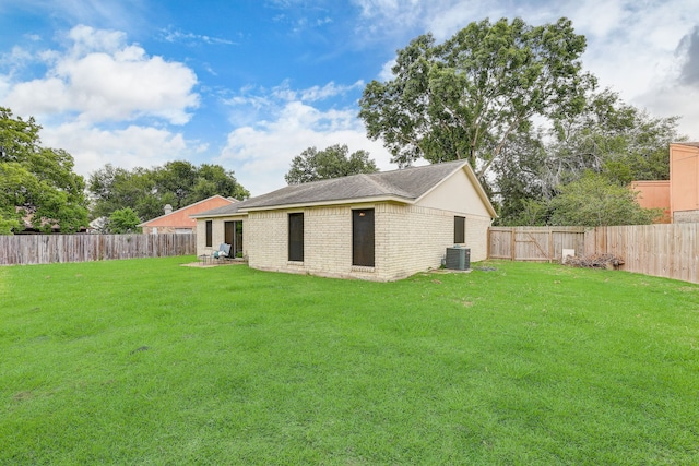 rear view of house with a lawn and central AC unit