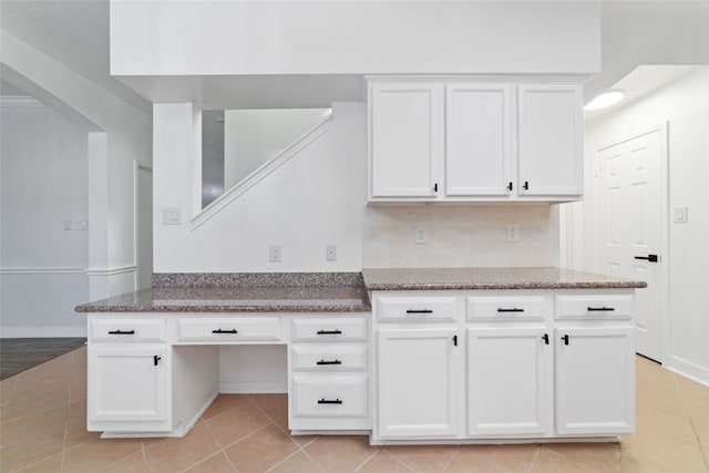 kitchen featuring white cabinets, decorative backsplash, light stone counters, and light tile patterned floors