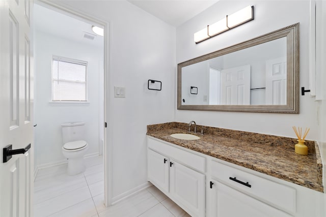 bathroom with tile patterned flooring, vanity, and toilet