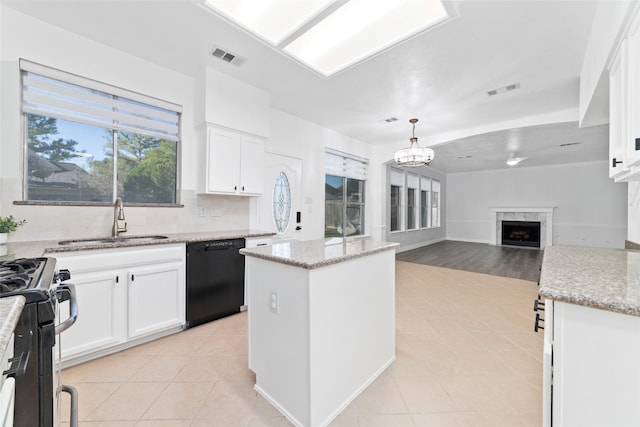 kitchen featuring white cabinetry, dishwasher, a center island, sink, and a high end fireplace