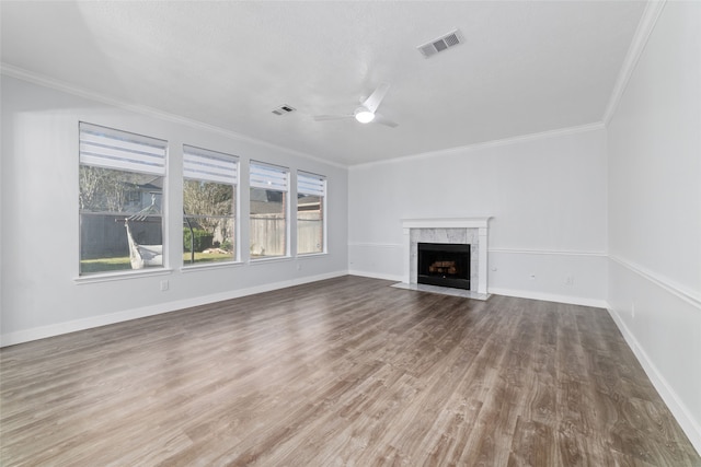 unfurnished living room featuring crown molding, a fireplace, ceiling fan, and wood-type flooring