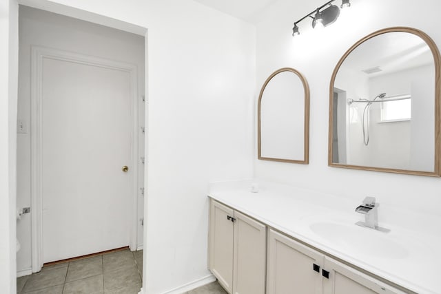 bathroom featuring tile patterned flooring, vanity, and walk in shower