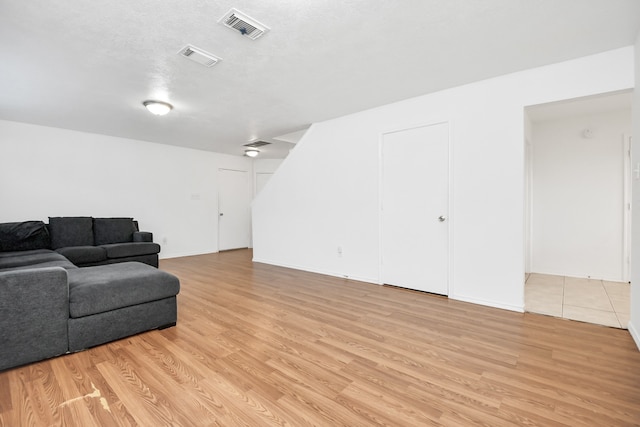 living room featuring light hardwood / wood-style floors and a textured ceiling