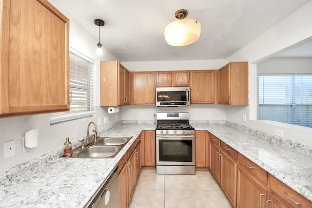 kitchen with appliances with stainless steel finishes, decorative light fixtures, plenty of natural light, and sink