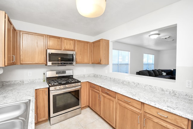 kitchen featuring appliances with stainless steel finishes, light tile patterned floors, and sink