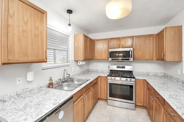 kitchen with light stone countertops, stainless steel appliances, sink, hanging light fixtures, and light tile patterned flooring