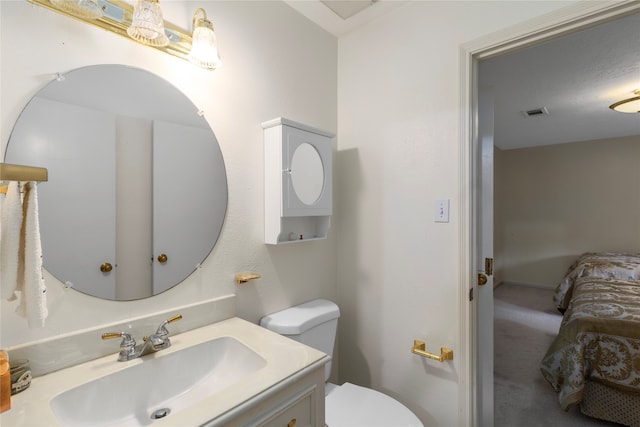 bathroom with vanity, toilet, and a textured ceiling