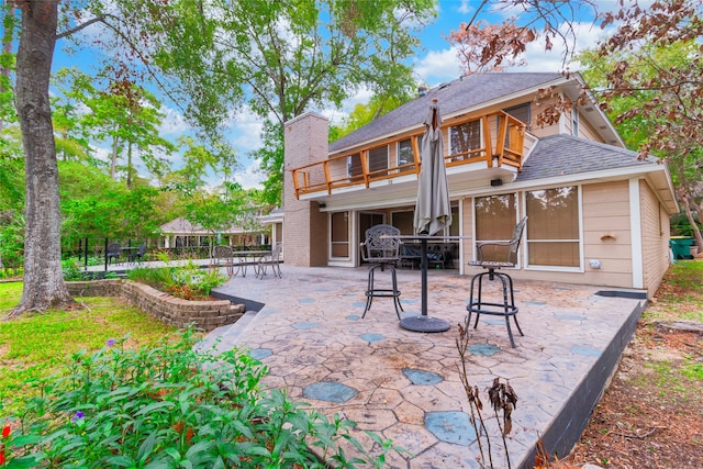 back of property featuring a balcony